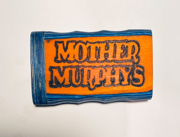 Fabric patch with orange center, black graffiti-style lettering, and blue patterned border