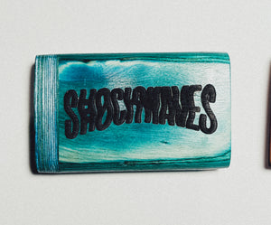 Teal wooden dugout with large distressed black “SHOEMAKERS” lettering