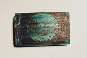 Wooden dugout with teal circle portrait logo on dark wood
