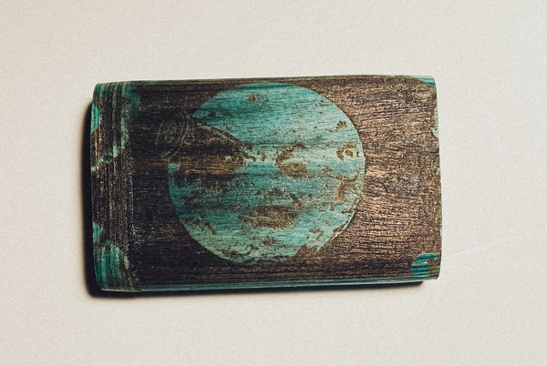 Wooden dugout with teal circle portrait logo on dark wood