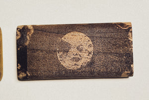 Wooden dugout with round face logo engraved on dark stained wood