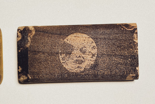 Wooden dugout with round face logo engraved on dark stained wood